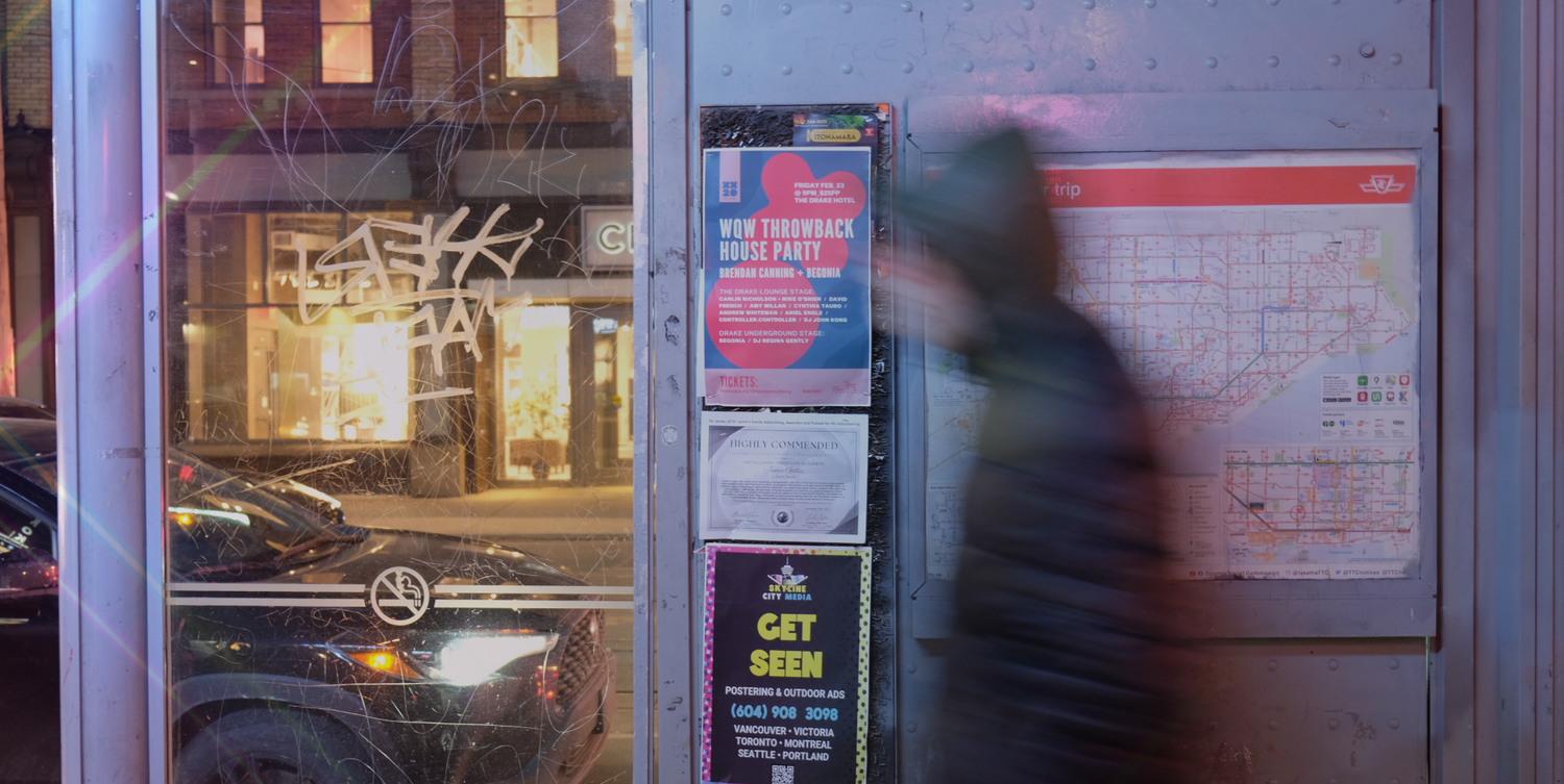 Skyline City Media's poster advertising at a Toronto bus stop with a pedestrian crossing quickly by.